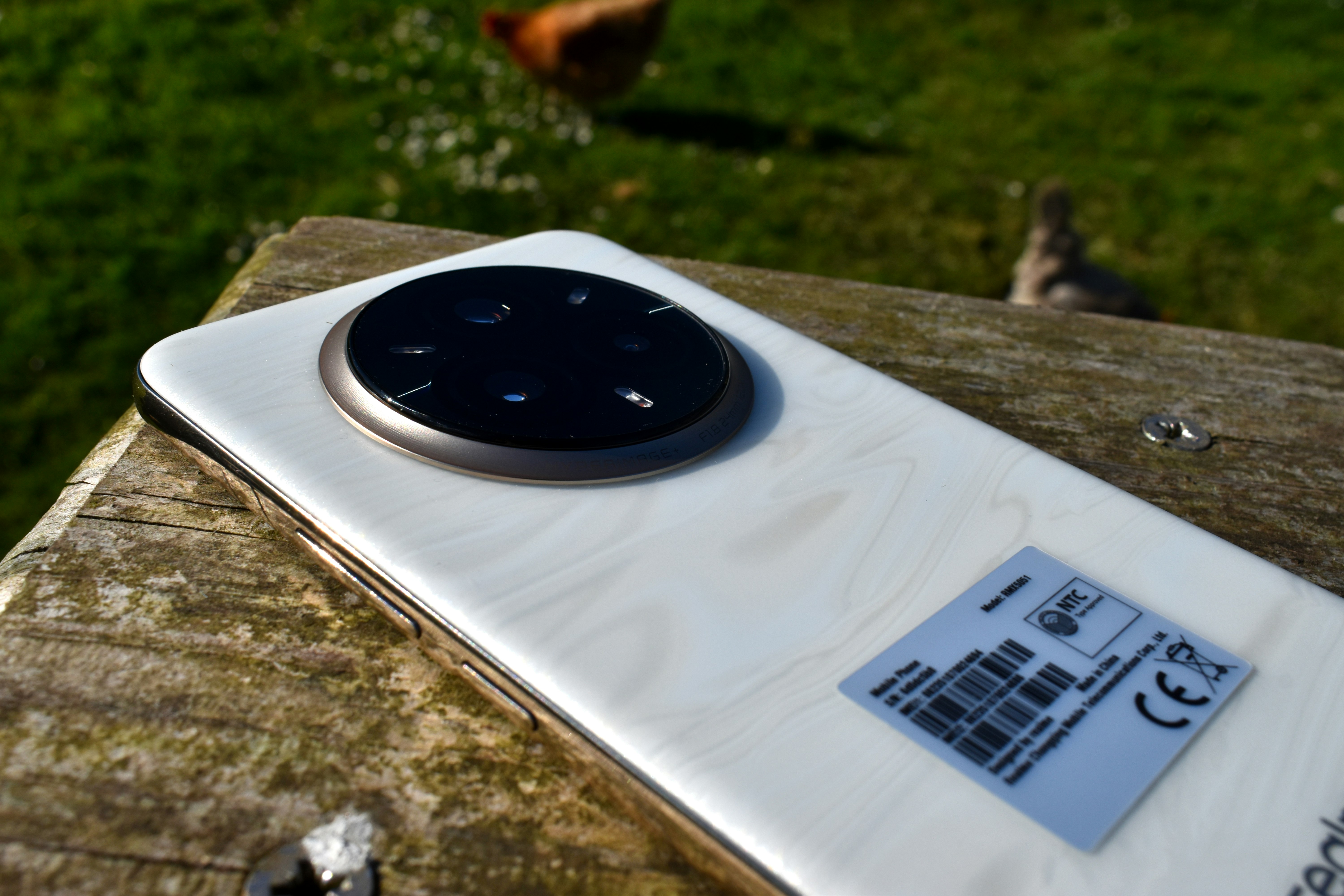 White smartphone on wooden surface outdoors